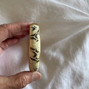 Croc striped leather bangle bracelet with gold tone hardware.